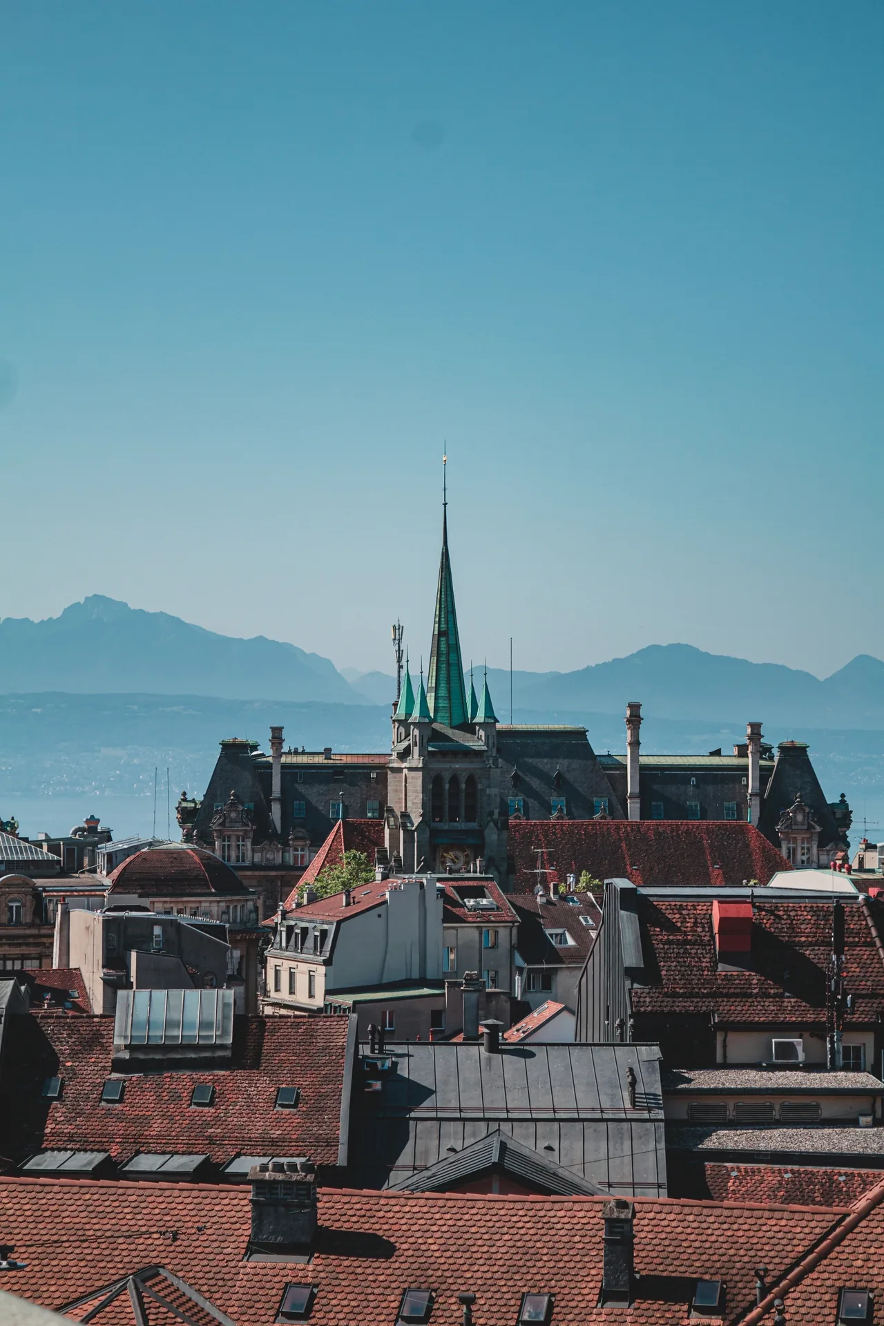 The rooftops of Lausanne and the cathedral spire, the Alps in the background.